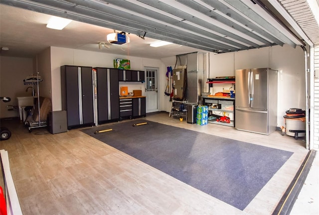 garage featuring stainless steel fridge and a garage door opener