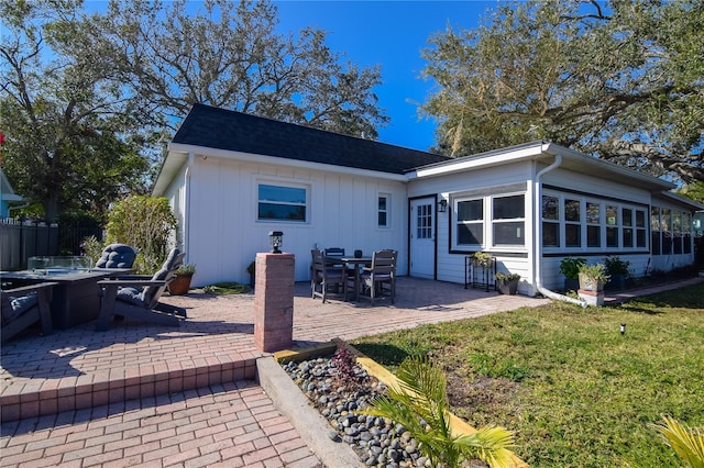 back of property with a patio and a lawn