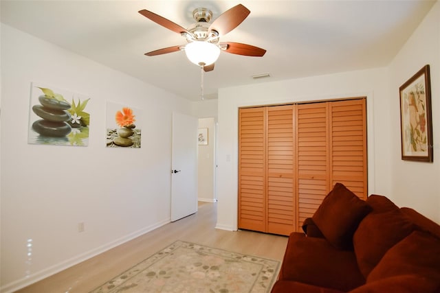 living room with ceiling fan and light wood-type flooring