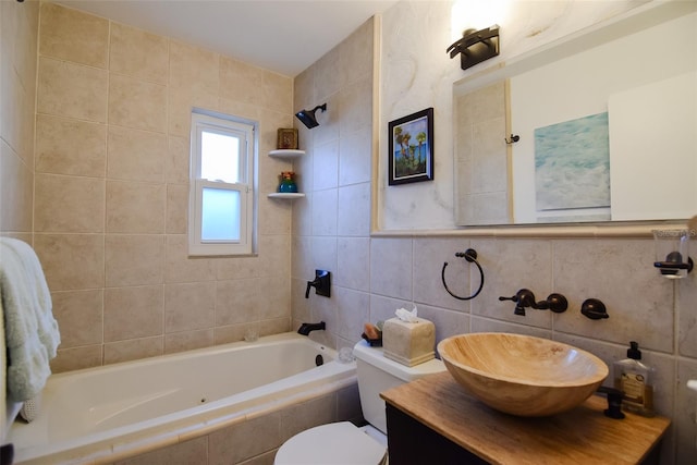 full bathroom featuring toilet, tiled shower / bath, vanity, and tile walls