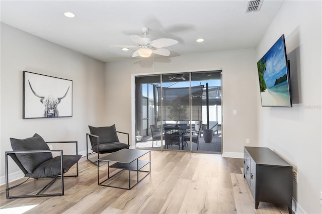 sitting room with ceiling fan and light hardwood / wood-style flooring