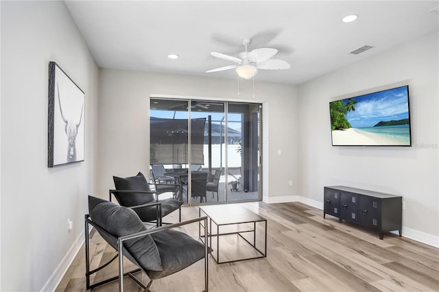 living room with ceiling fan and light wood-type flooring