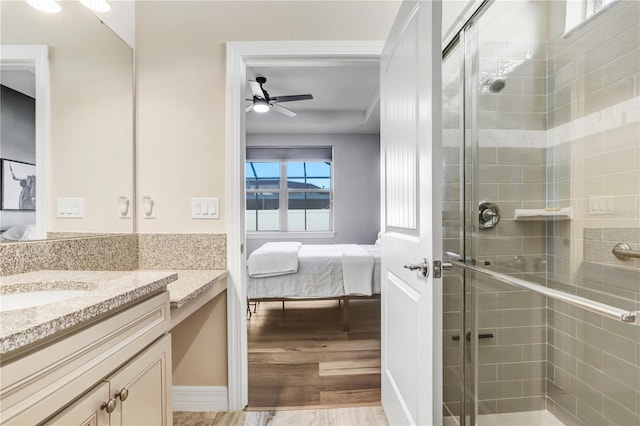 bathroom with vanity, ceiling fan, wood-type flooring, and a shower with shower door