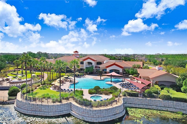 view of swimming pool with a patio, an in ground hot tub, and a water view