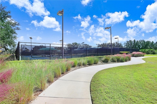 view of home's community featuring a yard and tennis court