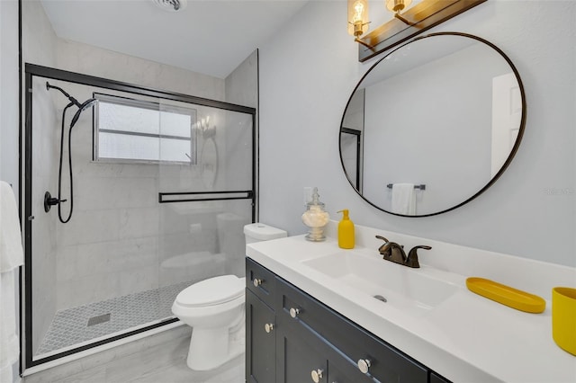 bathroom featuring vanity, toilet, and a shower with shower door