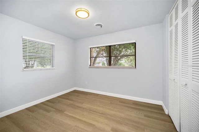 unfurnished bedroom with multiple windows and light wood-type flooring