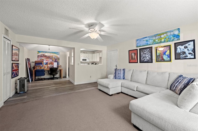 living room with a textured ceiling, hardwood / wood-style flooring, and ceiling fan