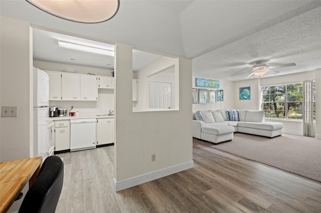 living room with sink, ceiling fan, a textured ceiling, and light hardwood / wood-style flooring