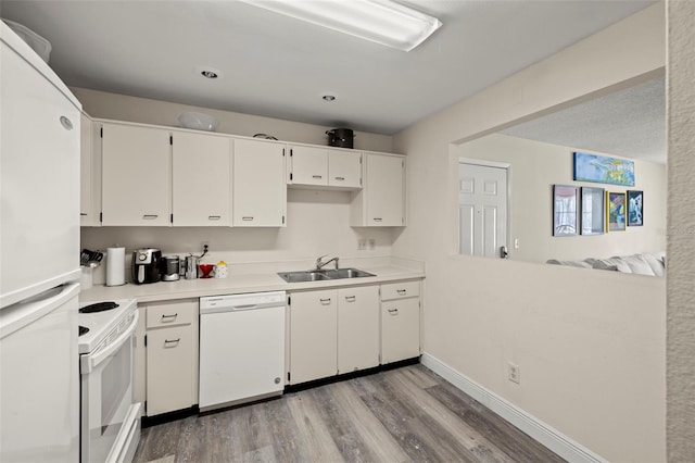 2101 Fox Chase Blvd Unit 106, Palm Harbor, FL 34683 - kitchen featuring white appliances, light wood-style floors, a sink, light countertops, and white cabinetry
