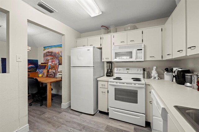 2101 Fox Chase Blvd Unit 106, Palm Harbor, FL 34683 - kitchen featuring white appliances, light wood-style flooring, white cabinetry, and light countertops