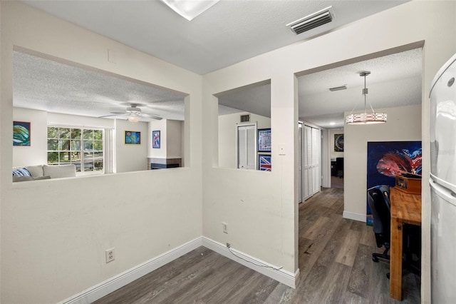 corridor with dark hardwood / wood-style floors and a textured ceiling