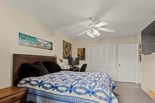 carpeted bedroom with a closet, a textured ceiling, and ceiling fan