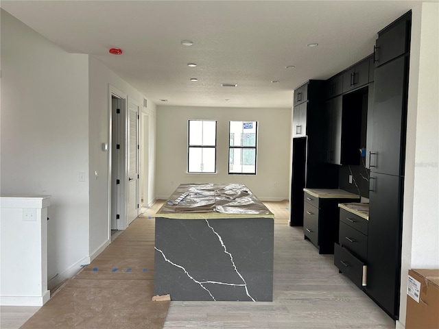 kitchen with a kitchen island and light hardwood / wood-style flooring