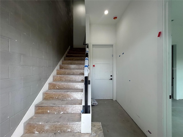 stairs with concrete flooring