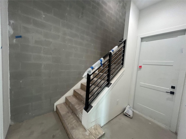 stairway featuring concrete flooring