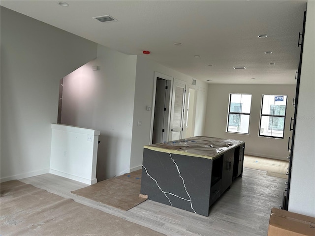 kitchen with a kitchen island and light hardwood / wood-style flooring