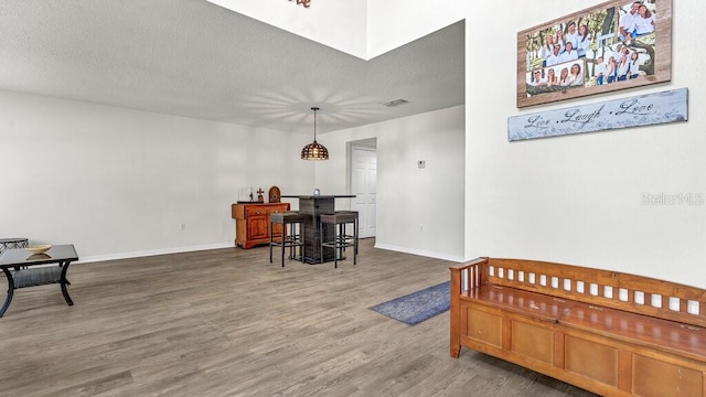 living area with a textured ceiling and hardwood / wood-style floors