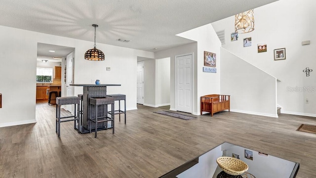 dining space with dark wood-type flooring and a textured ceiling