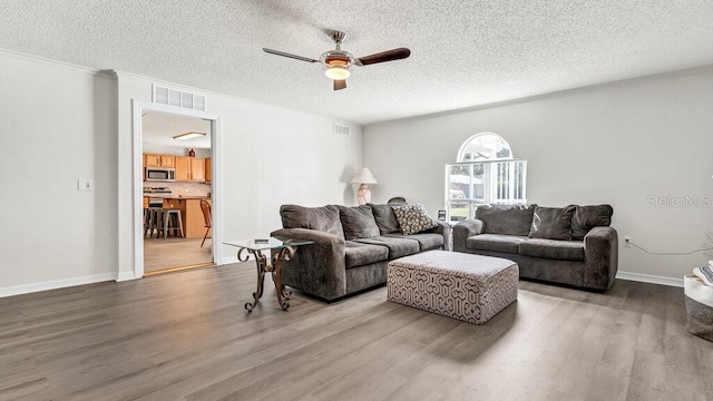 living room featuring ornamental molding, a textured ceiling, hardwood / wood-style flooring, and ceiling fan