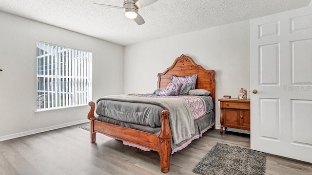 bedroom featuring a textured ceiling, wood-type flooring, and ceiling fan