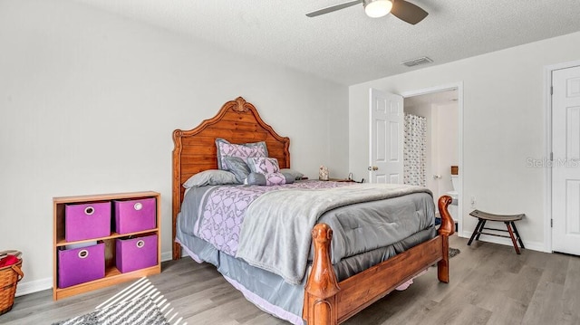 bedroom featuring ceiling fan, wood-type flooring, and a textured ceiling