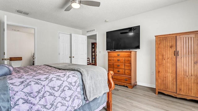 bedroom with ceiling fan, a textured ceiling, and light wood-type flooring