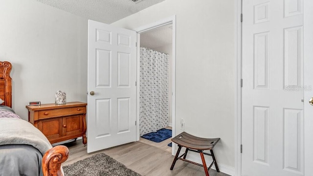 bedroom with a textured ceiling and light wood-type flooring