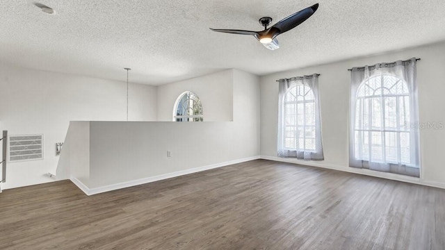 unfurnished room featuring ceiling fan, a textured ceiling, and dark hardwood / wood-style flooring