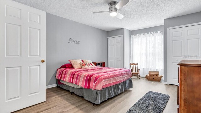 bedroom featuring ceiling fan, a textured ceiling, and light wood-type flooring