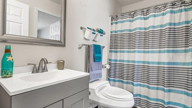 bathroom featuring vanity, toilet, a textured ceiling, and walk in shower