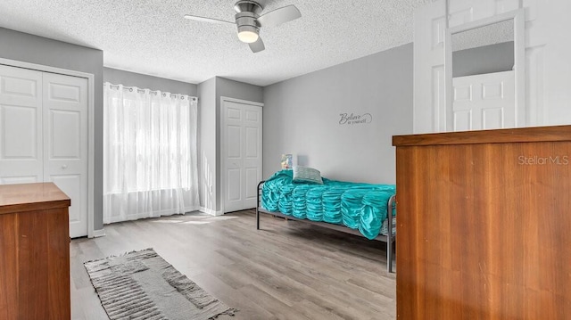 bedroom with ceiling fan, a textured ceiling, and light wood-type flooring