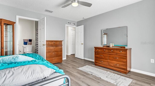 bedroom with ceiling fan, hardwood / wood-style flooring, and a textured ceiling