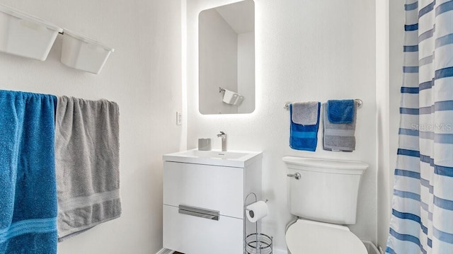 bathroom featuring vanity, toilet, and curtained shower