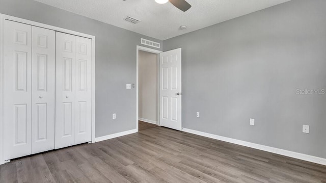 unfurnished bedroom with a closet, ceiling fan, a textured ceiling, and light wood-type flooring