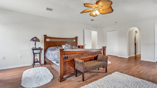 bedroom with a closet, ceiling fan, a textured ceiling, and light wood-type flooring