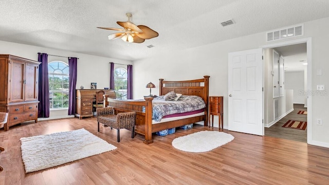 bedroom featuring ceiling fan, a textured ceiling, and light wood-type flooring