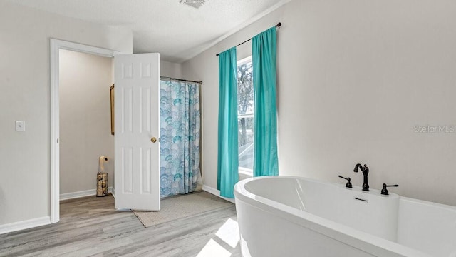 bathroom featuring wood-type flooring and a bathtub