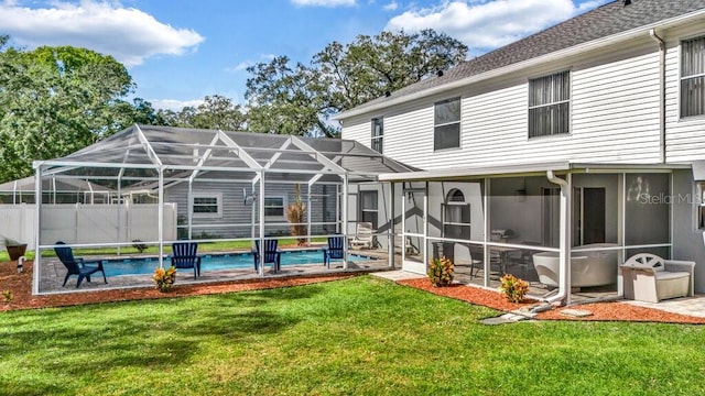 rear view of house with a patio area, glass enclosure, a sunroom, a fenced in pool, and a lawn