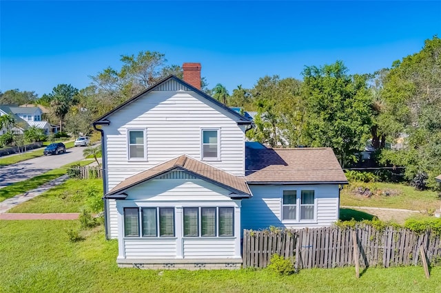 back of property featuring a lawn