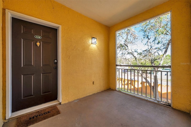 view of exterior entry with a balcony