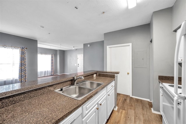 kitchen featuring white cabinets, range, sink, and light hardwood / wood-style flooring