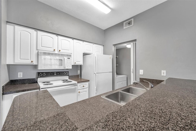 kitchen featuring white appliances, a textured ceiling, sink, white cabinets, and washer / dryer