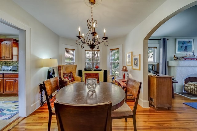 dining room featuring a healthy amount of sunlight, light hardwood / wood-style flooring, and a chandelier