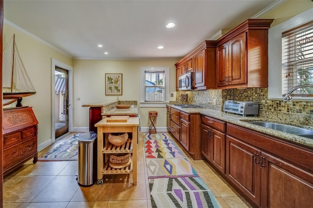 kitchen with ornamental molding, sink, appliances with stainless steel finishes, and plenty of natural light