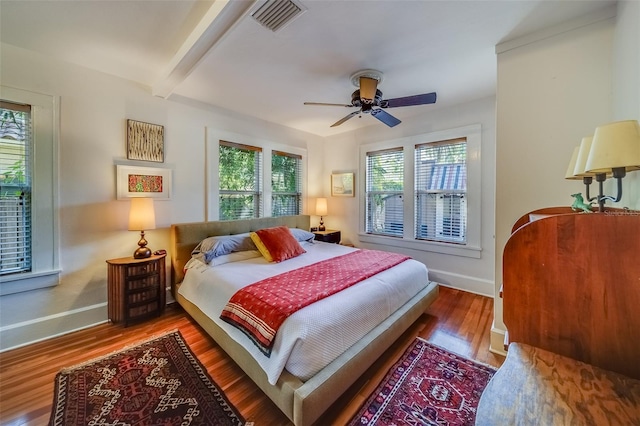 bedroom with hardwood / wood-style floors, beam ceiling, and ceiling fan