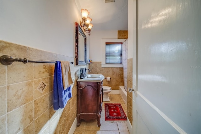 full bathroom featuring toilet, tile walls, vanity, tile patterned flooring, and shower / bathtub combination