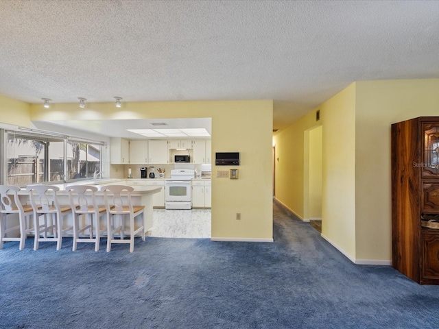 kitchen featuring a breakfast bar, white cabinetry, a textured ceiling, carpet floors, and white range with electric stovetop