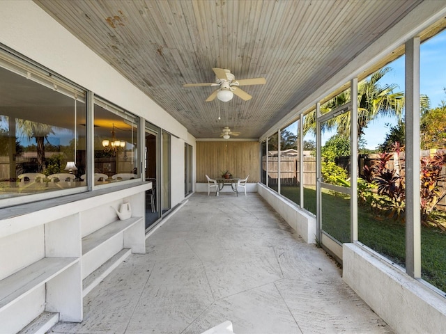 unfurnished sunroom with wood ceiling and ceiling fan