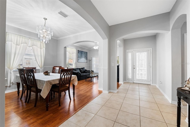 dining space featuring ceiling fan with notable chandelier, light hardwood / wood-style floors, and ornamental molding